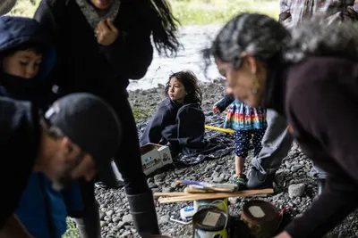 Friends including Jay Lundahl (painting with extension roller), Theresa Churchill (looking up), and others gather under a bridge to paint over hateful graffiti in Sequim, Washington on June 17, 2023.